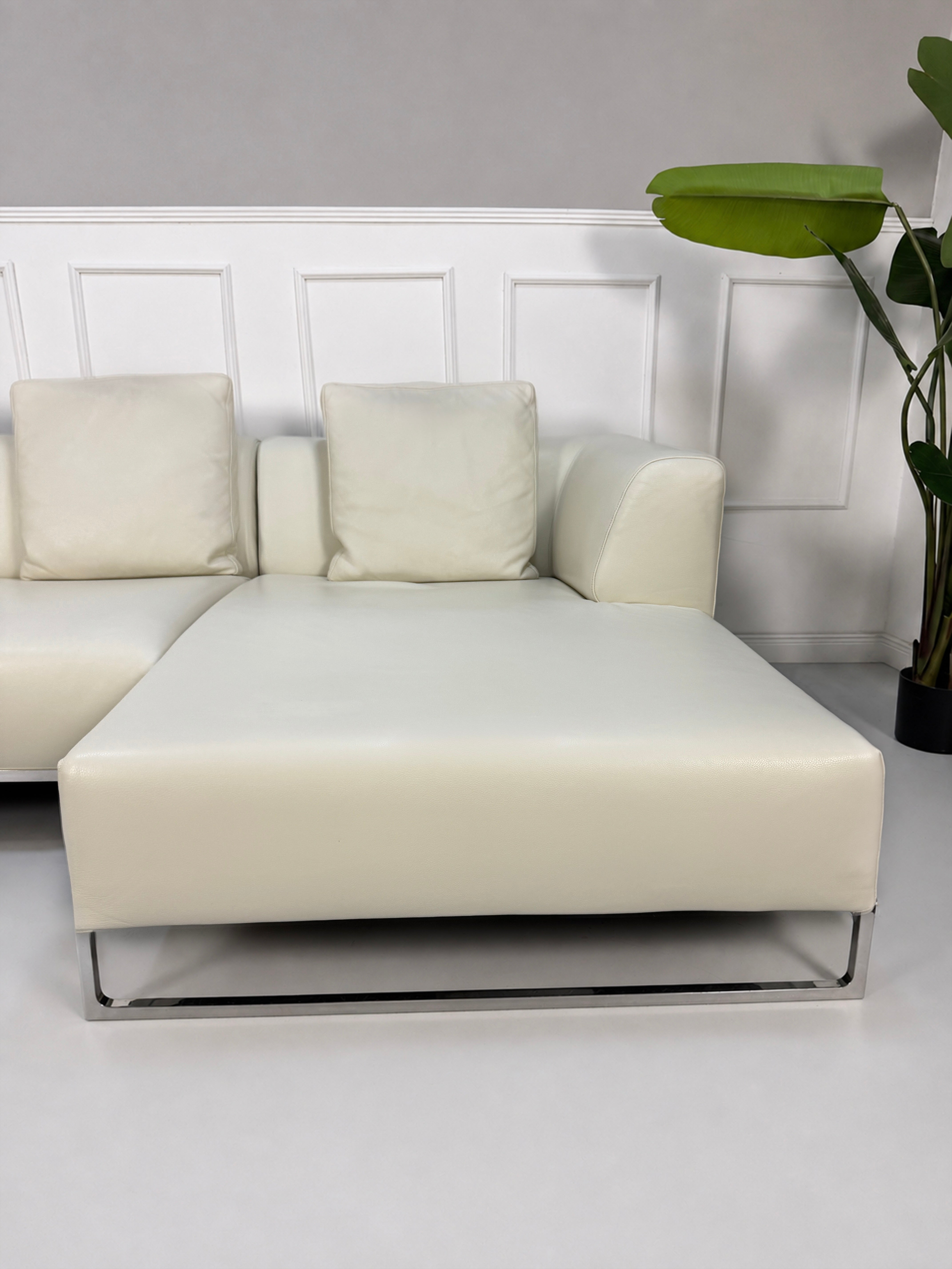 Gebrauchtes weißes B&B Italia Solo Designer Leder Sofa vor einer Wand, stilvoll und modern eingerichtet.