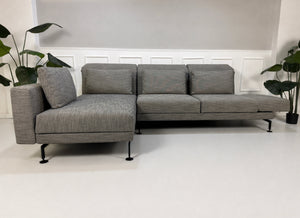 Gebrauchtes graues Brühl Moule Designer Stoff Sofa vor einer Wand, stilvoll und modern eingerichtet.