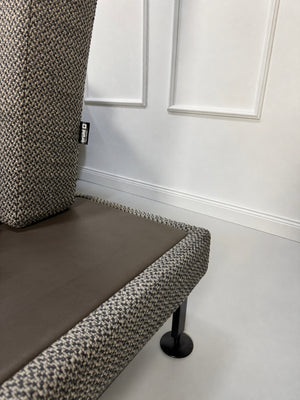Gebrauchtes graues Brühl Moule Designer Stoff Sofa vor einer Wand, stilvoll und modern eingerichtet.