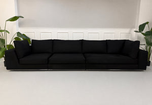 Gebrauchtes graues Minotti Hamilton Designer Stoff Sofa vor einer Wand, stilvoll und modern eingerichtet.