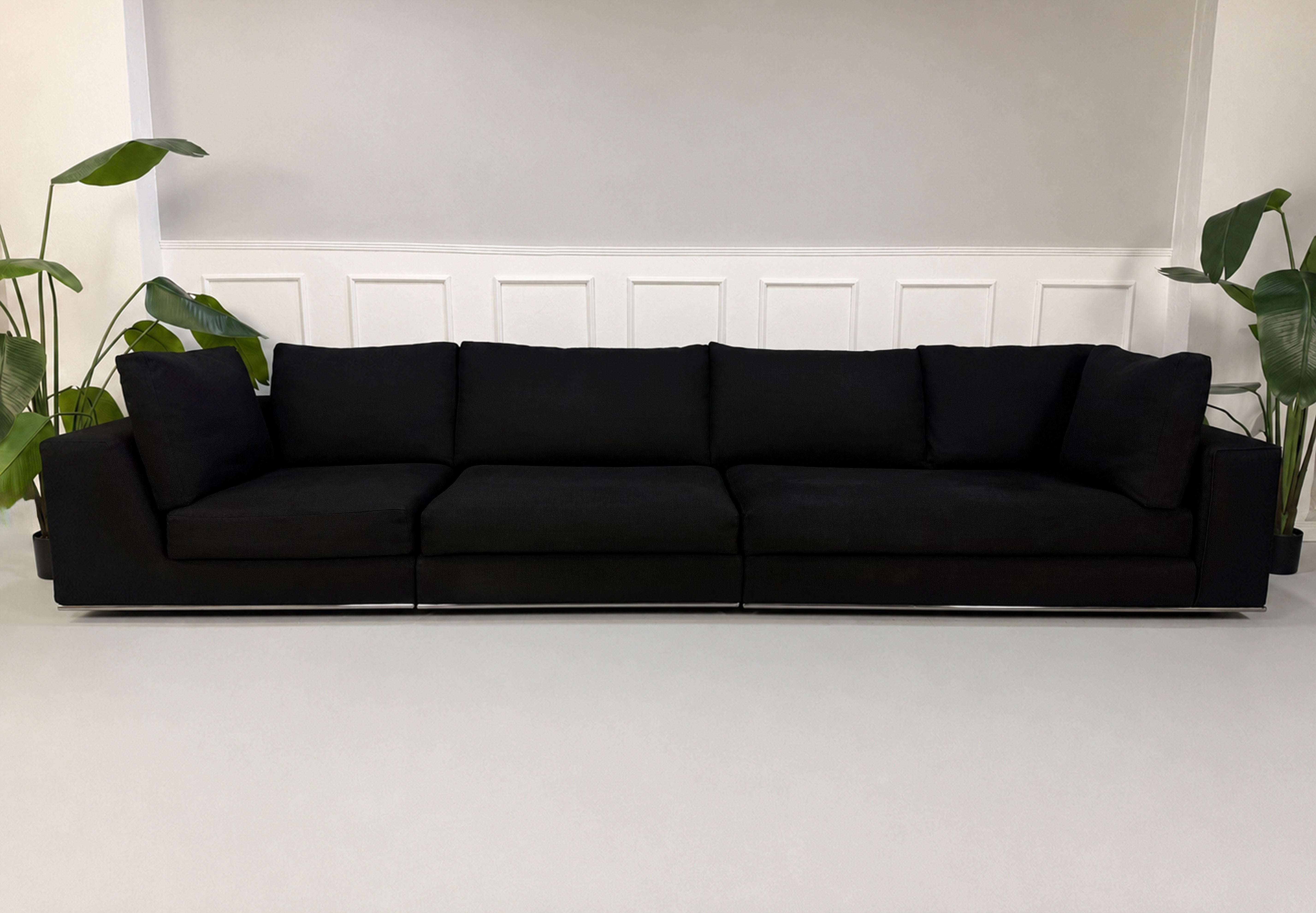 Gebrauchtes graues Minotti Hamilton Designer Stoff Sofa vor einer Wand, stilvoll und modern eingerichtet.