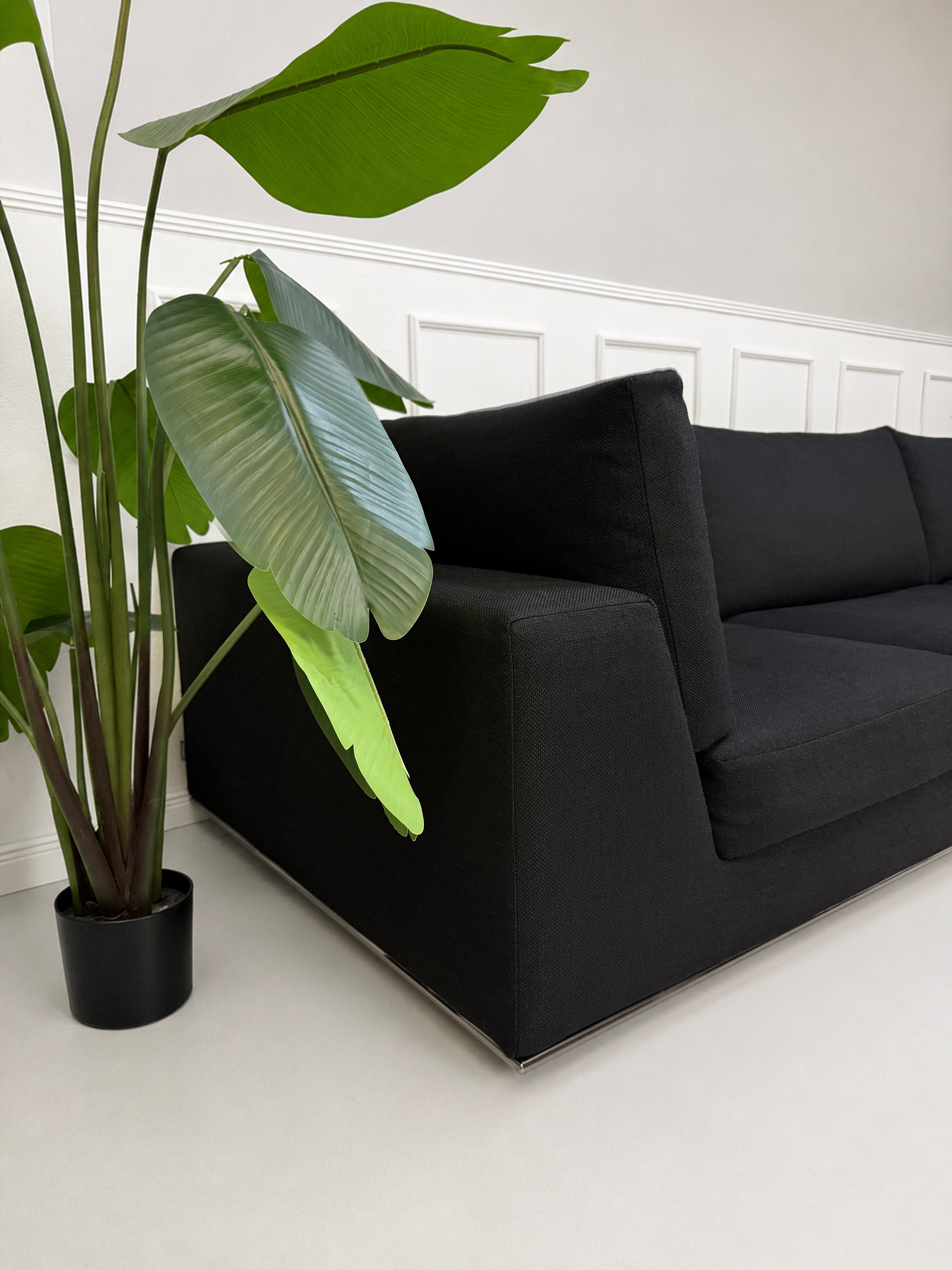 Gebrauchtes graues Minotti Hamilton Designer Stoff Sofa vor einer Wand, stilvoll und modern eingerichtet.