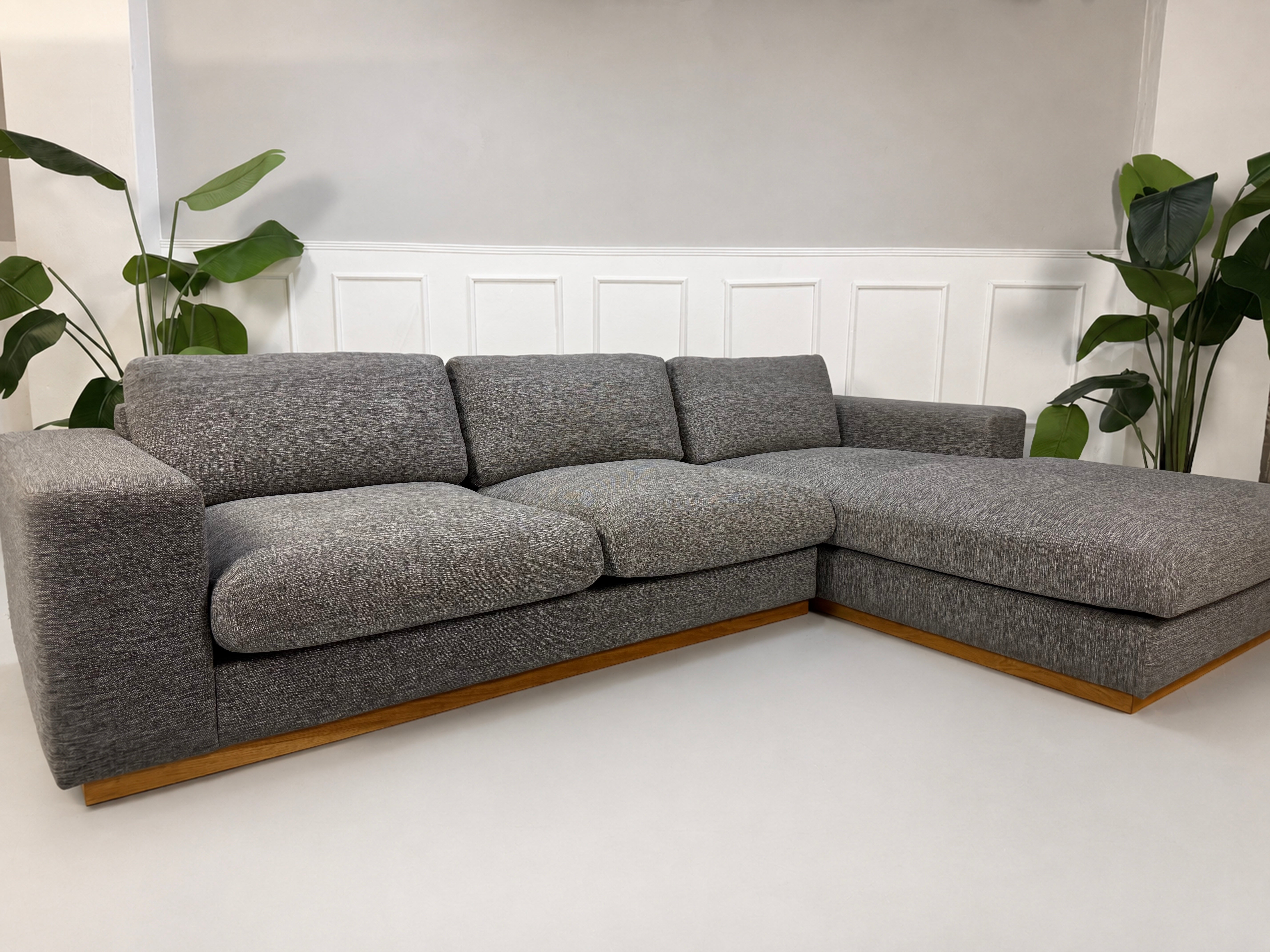 Gebrauchtes graues Bolia Sepia Designer Stoff Sofa vor einer Wand, stilvoll und modern eingerichtet.