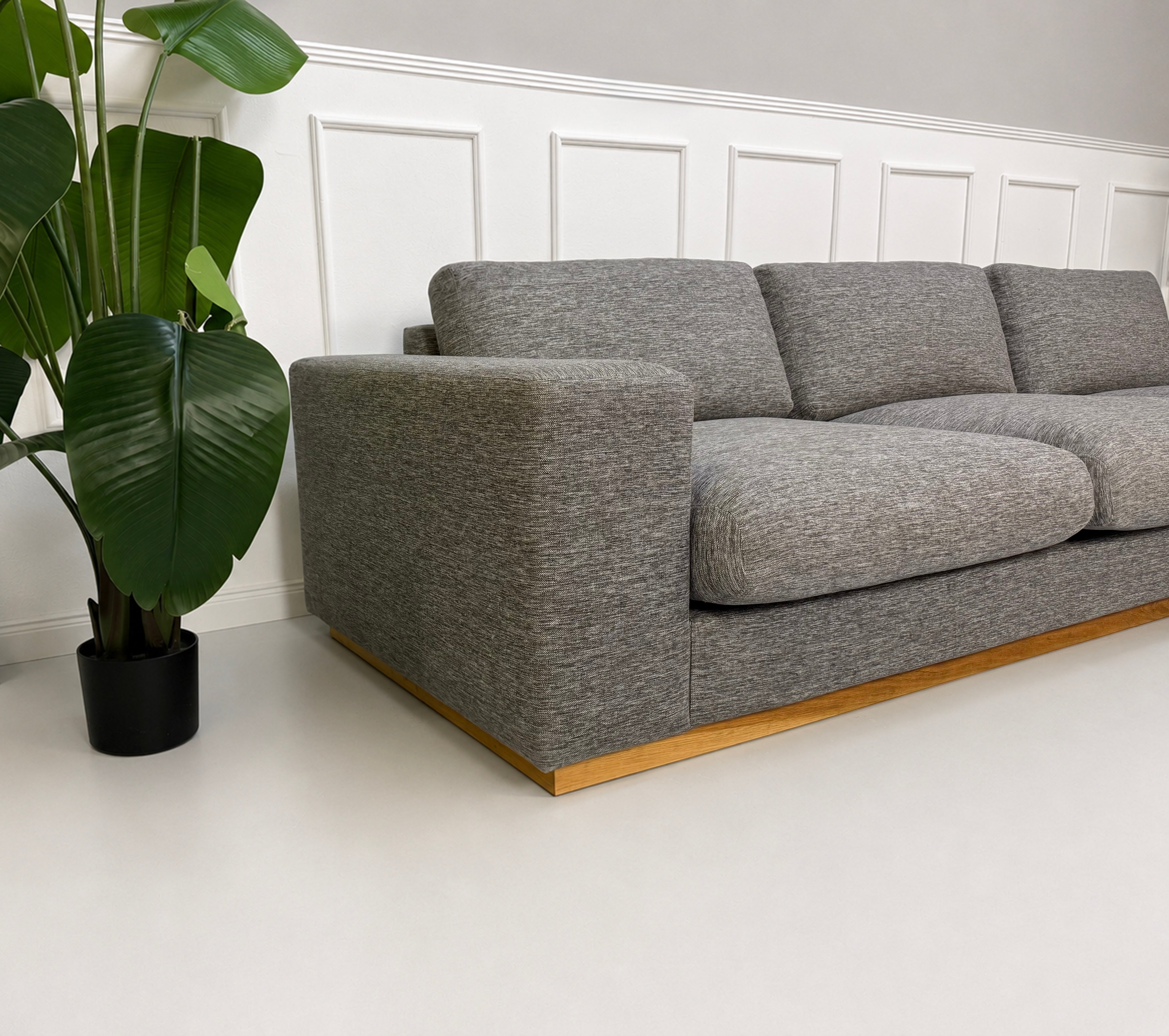 Gebrauchtes graues Bolia Sepia Designer Stoff Sofa vor einer Wand, stilvoll und modern eingerichtet.