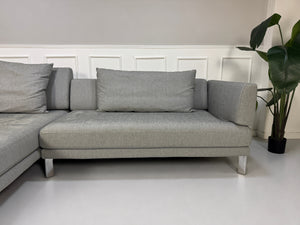 Gebrauchtes graues Rolf Benz Sento Designer Stoff Sofa vor einer Wand, stilvoll und modern eingerichtet.