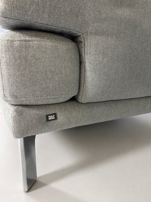 Gebrauchtes graues Rolf Benz Sento Designer Stoff Sofa vor einer Wand, stilvoll und modern eingerichtet.