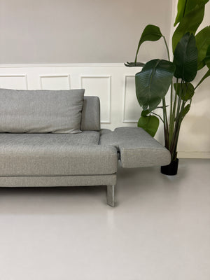 Gebrauchtes graues Rolf Benz Sento Designer Stoff Sofa vor einer Wand, stilvoll und modern eingerichtet.