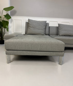 Gebrauchtes graues Rolf Benz Sento Designer Stoff Sofa vor einer Wand, stilvoll und modern eingerichtet.