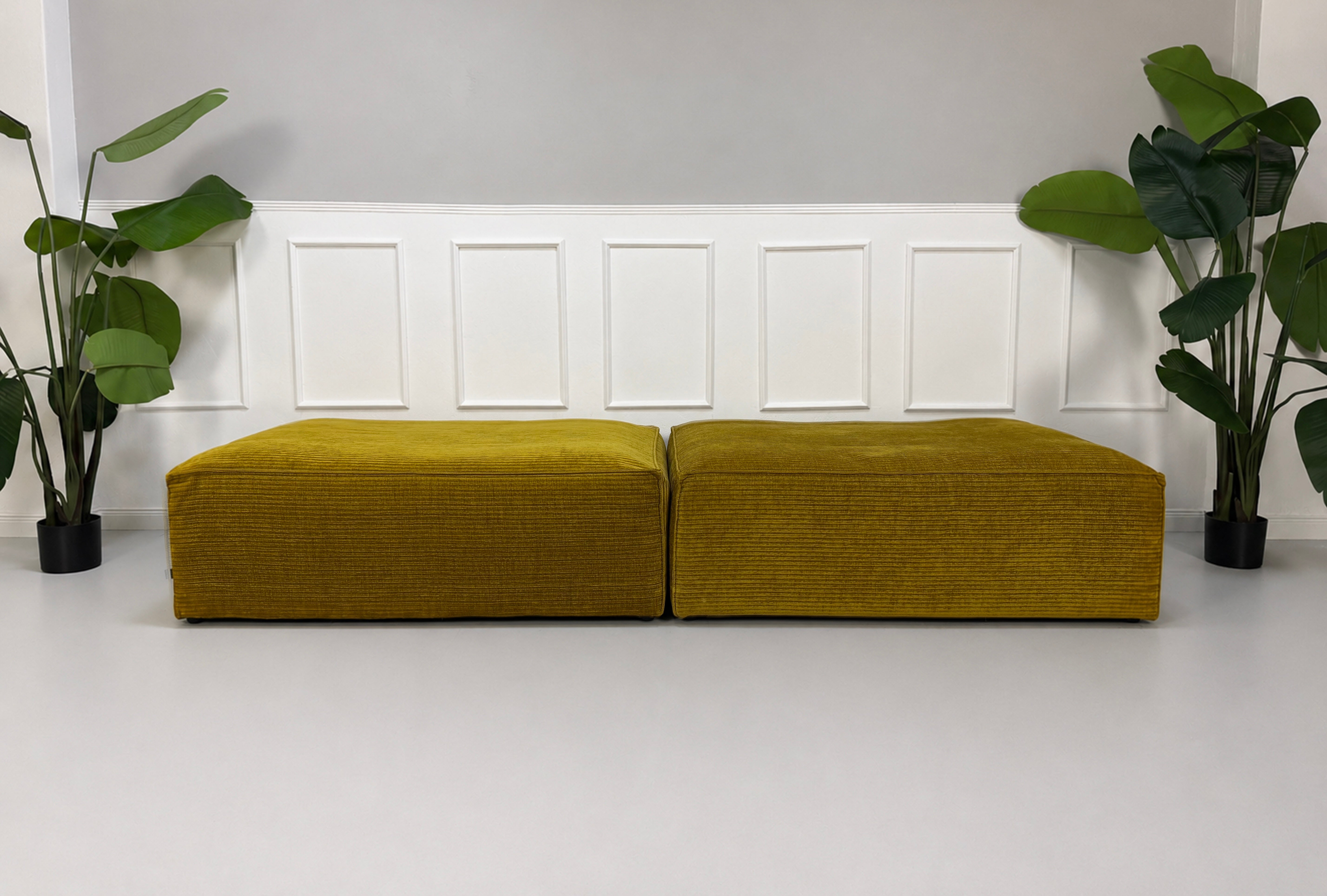 Gebrauchte gelbe Bolia Cosima Designer Stoff Hocker vor einer Wand, stilvoll und modern eingerichtet.