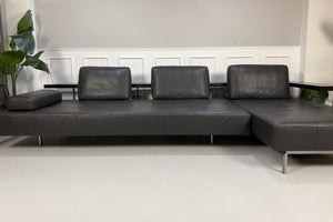 Gebrauchtes graues Rolf Benz Dono Designer Leder Sofa vor einer Wand, stilvoll und modern eingerichtet.