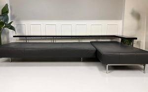 Gebrauchtes graues Rolf Benz Dono Designer Leder Sofa vor einer Wand, stilvoll und modern eingerichtet.