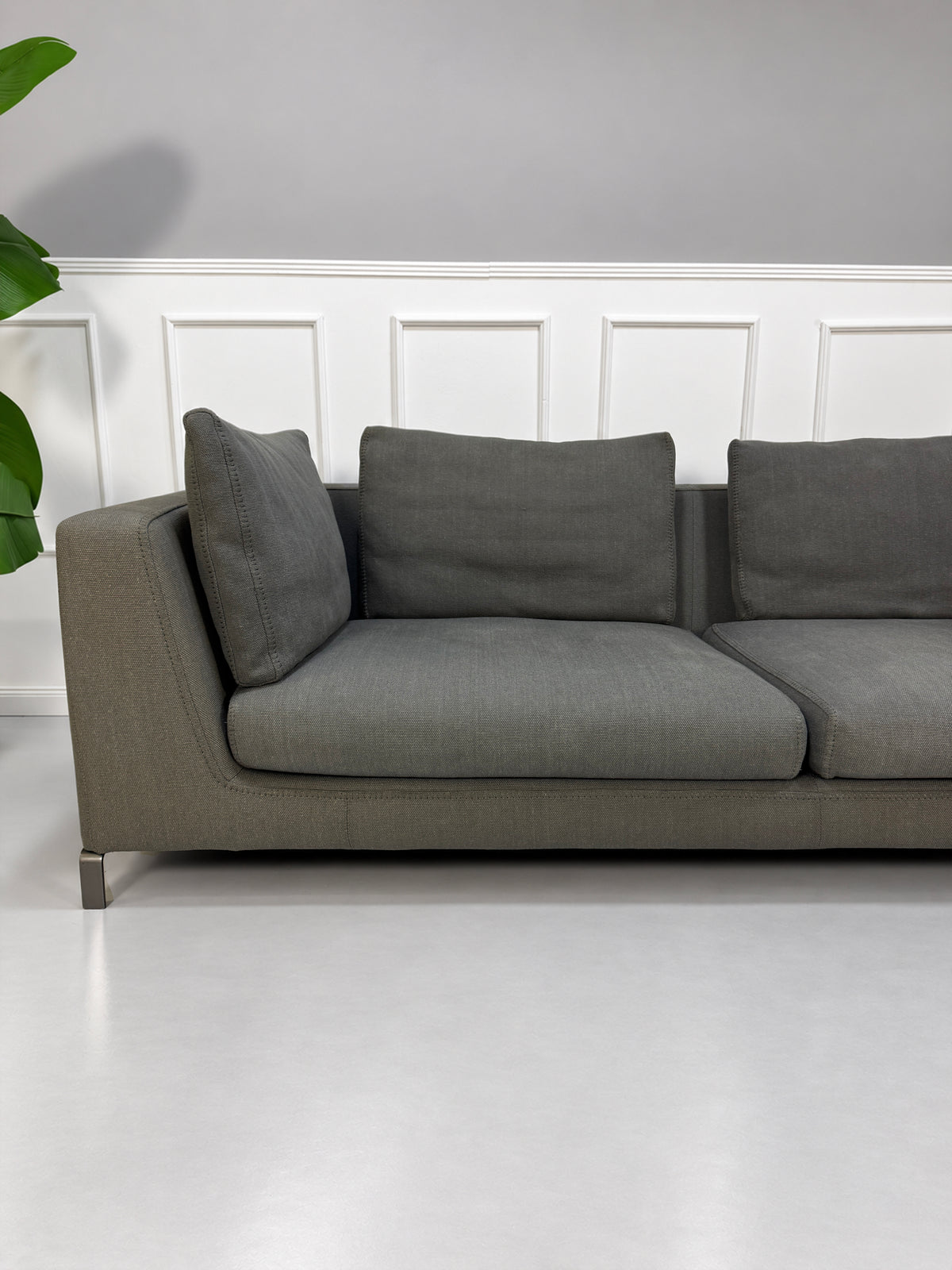 Gebrauchtes graues B&B Italia Ray Designer Stoff Sofa vor einer Wand, stilvoll und modern eingerichtet.