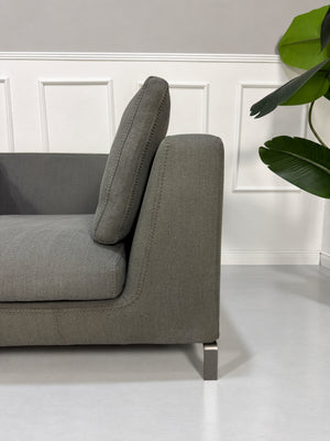Gebrauchtes graues B&B Italia Ray Designer Stoff Sofa vor einer Wand, stilvoll und modern eingerichtet.