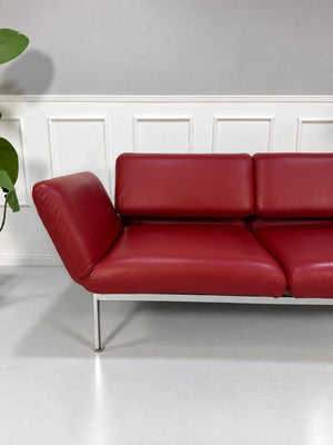Gebrauchtes rotes Brühl Roro Medium Designer Leder Sofa vor einer Wand, stilvoll und modern eingerichtet.