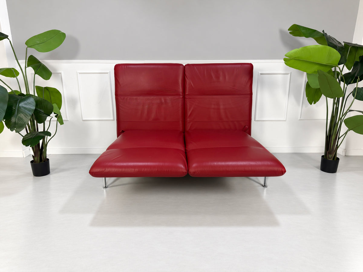Gebrauchtes rotes Brühl Roro Medium Designer Leder Sofa vor einer Wand, stilvoll und modern eingerichtet.