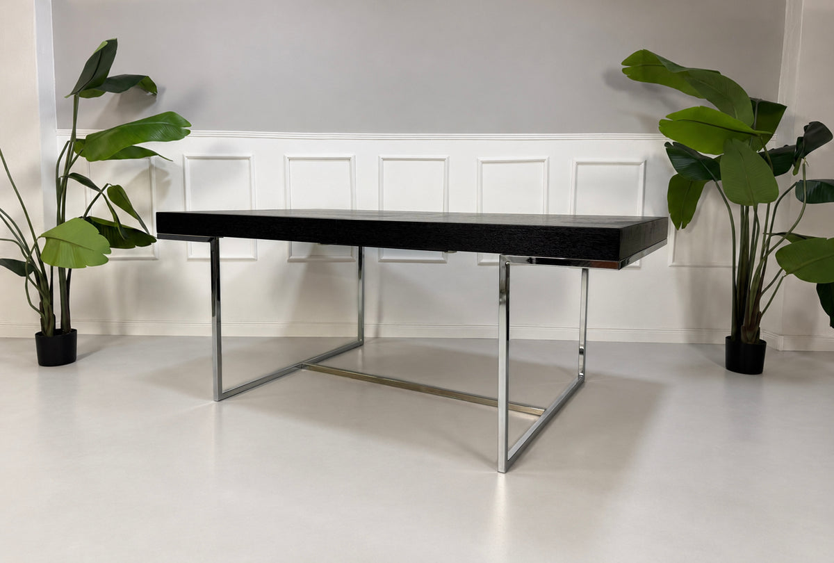 Gebrauchter grauer B&B Italia Athos Designer Chrom Tisch vor einer Wand, stilvoll und modern eingerichtet.