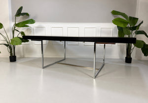Gebrauchter grauer B&B Italia Athos Designer Chrom Tisch vor einer Wand, stilvoll und modern eingerichtet.