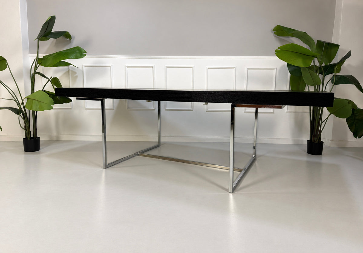 Gebrauchter grauer B&B Italia Athos Designer Chrom Tisch vor einer Wand, stilvoll und modern eingerichtet.