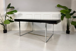 Gebrauchter grauer B&B Italia Athos Designer Chrom Tisch vor einer Wand, stilvoll und modern eingerichtet.