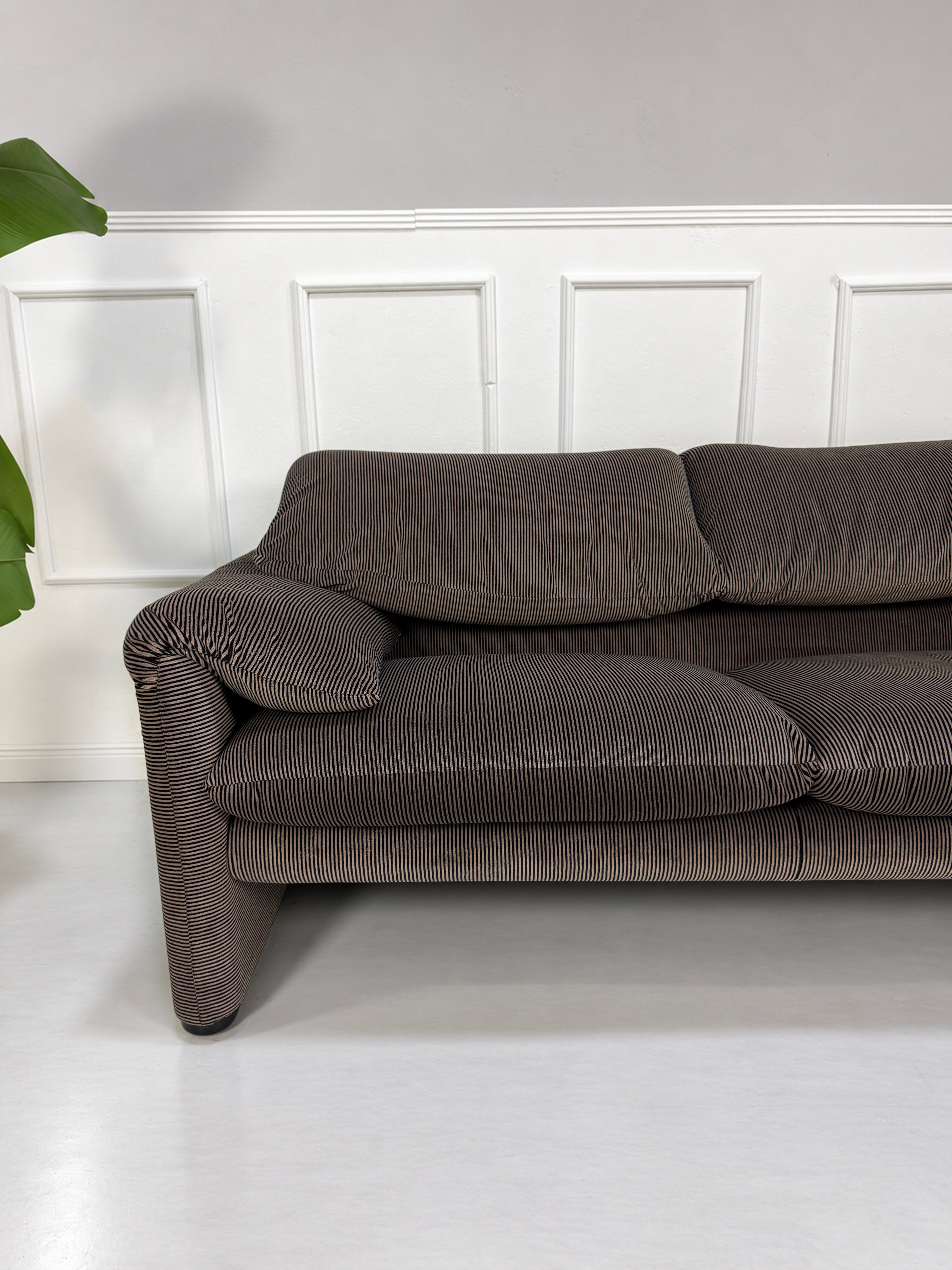 Gebrauchtes braun-schwarzes Cassina Maralunga Designer Stoff Sofa vor einer Wand, stilvoll und modern eingerichtet.