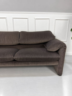 Gebrauchtes braun-schwarzes Cassina Maralunga Designer Stoff Sofa vor einer Wand, stilvoll und modern eingerichtet.