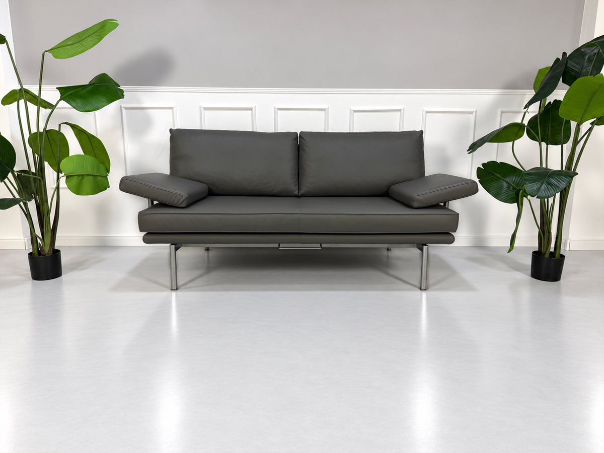 Gebrauchtes graues Walter Knoll Living Platform Designer Leder Sofa vor einer Wand, stilvoll und modern eingerichtet.