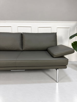 Gebrauchtes graues Walter Knoll Living Platform Designer Leder Sofa vor einer Wand, stilvoll und modern eingerichtet.