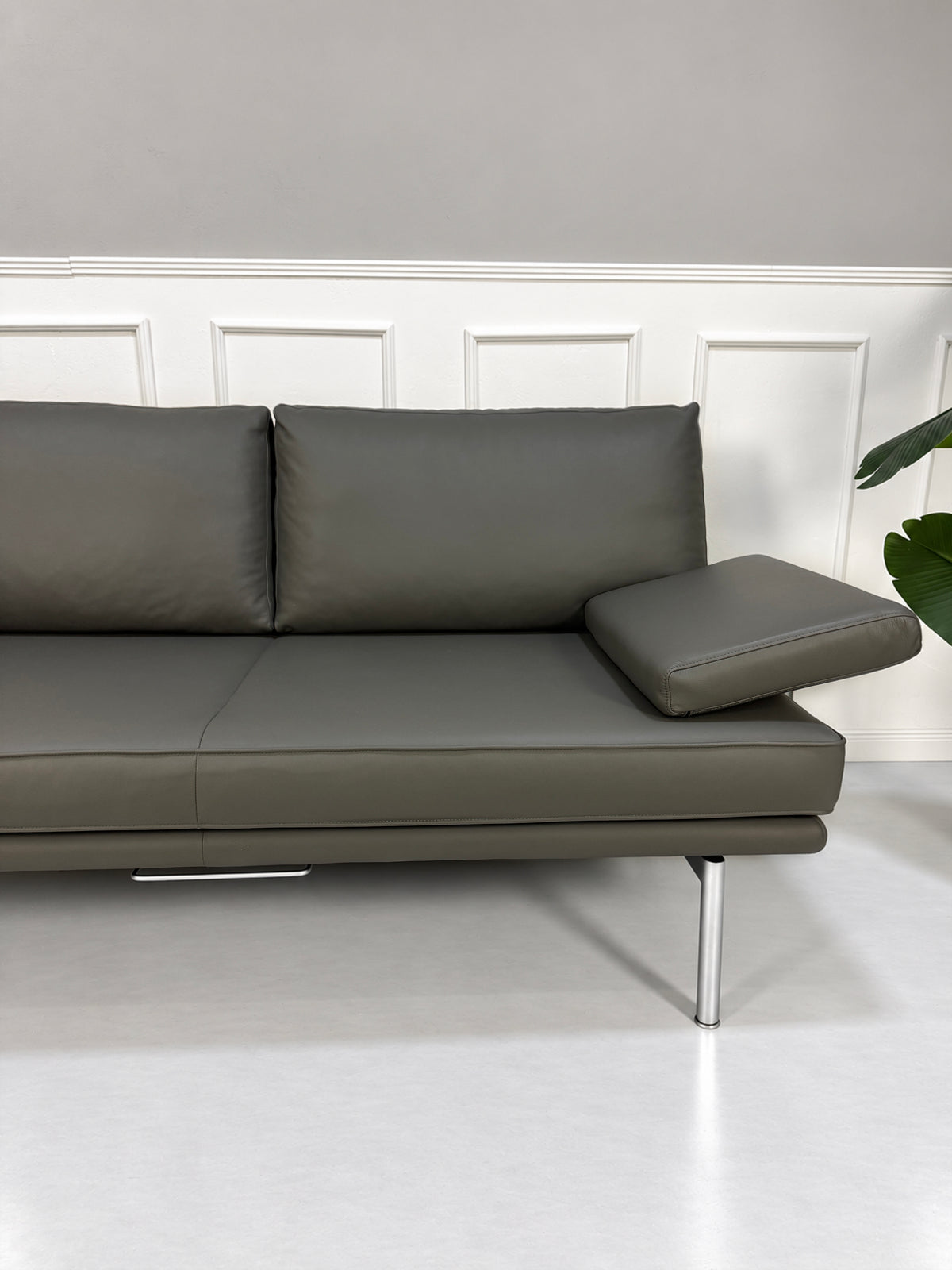 Gebrauchtes graues Walter Knoll Living Platform Designer Leder Sofa vor einer Wand, stilvoll und modern eingerichtet.
