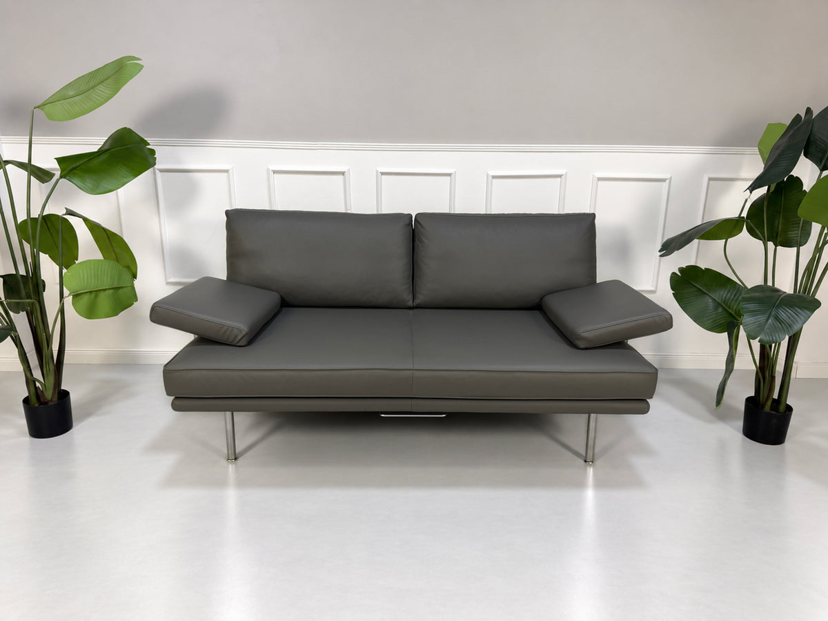 Gebrauchtes graues Walter Knoll Living Platform Designer Leder Sofa vor einer Wand, stilvoll und modern eingerichtet.