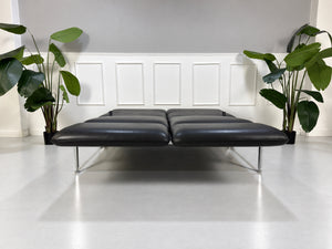 Gebrauchtes graues Brühl Roro Medium Designer Leder Sofa vor einer Wand, stilvoll und modern eingerichtet.