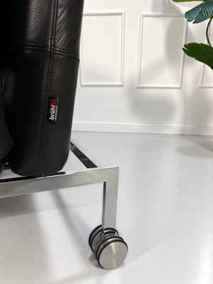 Gebrauchtes graues Brühl Roro Medium Designer Leder Sofa vor einer Wand, stilvoll und modern eingerichtet.