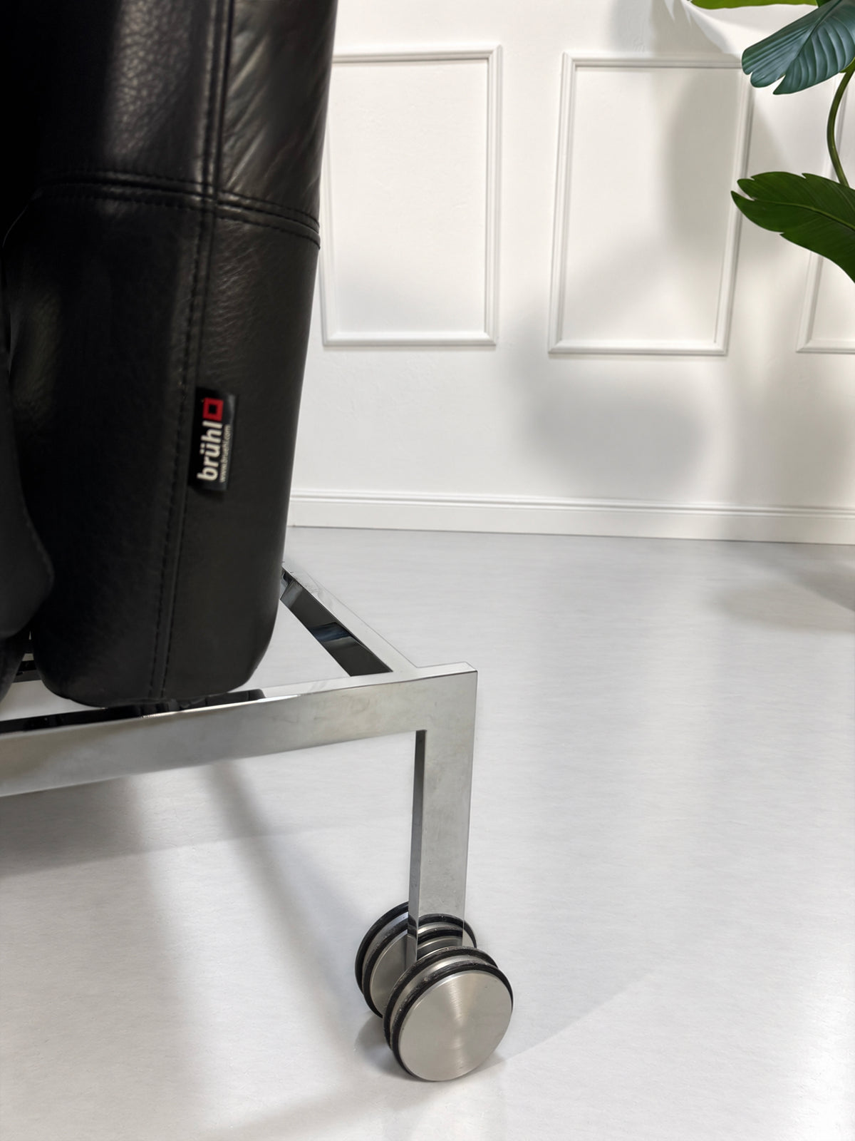 Gebrauchtes graues Brühl Roro Medium Designer Leder Sofa vor einer Wand, stilvoll und modern eingerichtet.