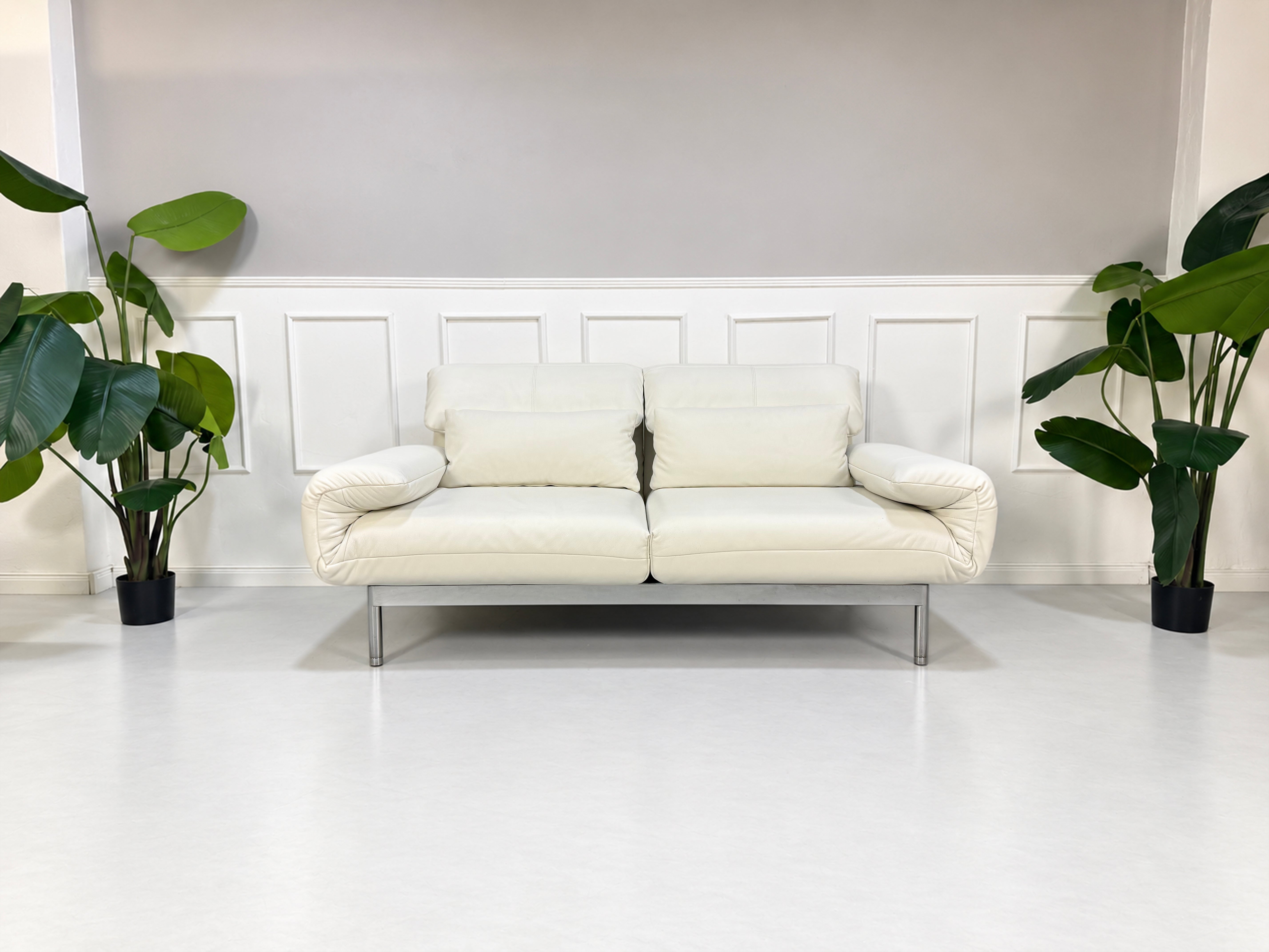 Gebrauchtes weißes Rolf Benz Plura 380 Designer Leder Sofa vor einer Wand, stilvoll und modern eingerichtet.