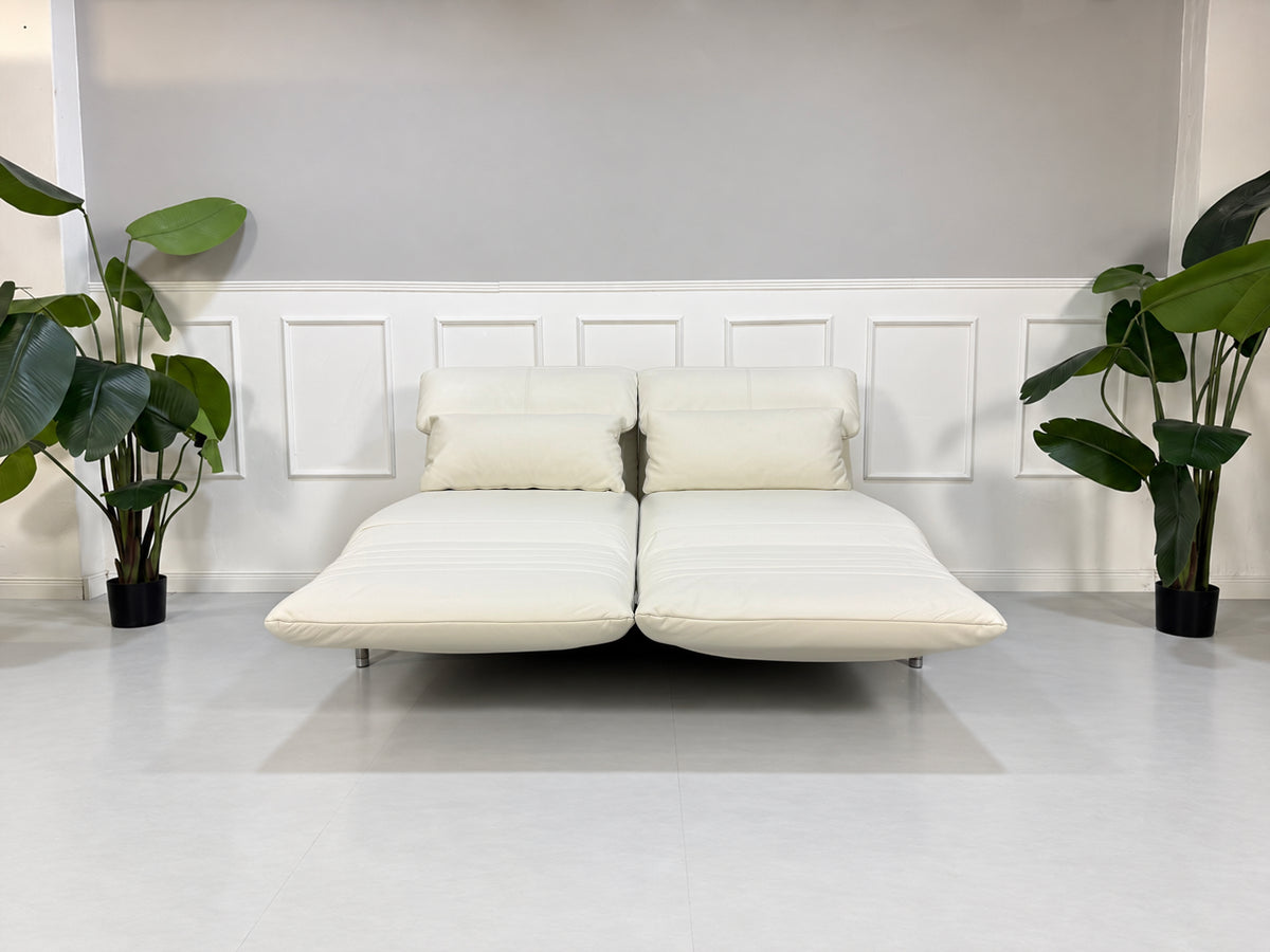 Gebrauchtes weißes Rolf Benz Plura 380 Designer Leder Sofa vor einer Wand, stilvoll und modern eingerichtet.