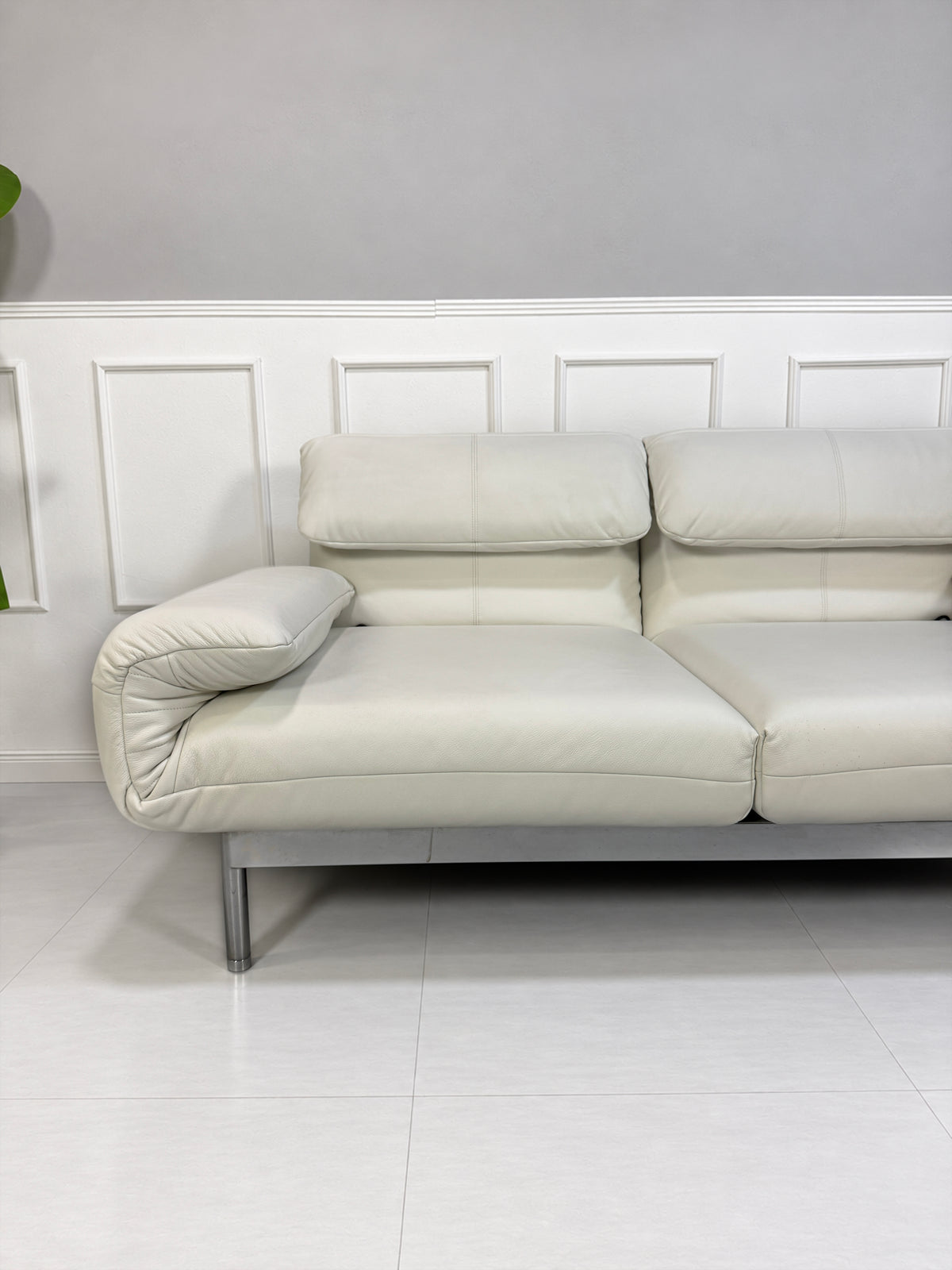 Gebrauchtes weißes Rolf Benz Plura 380 Designer Leder Sofa vor einer Wand, stilvoll und modern eingerichtet.
