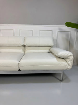 Gebrauchtes weißes Rolf Benz Plura 380 Designer Leder Sofa vor einer Wand, stilvoll und modern eingerichtet.