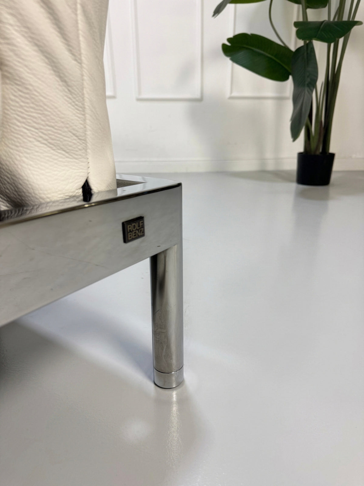 Gebrauchtes weißes Rolf Benz Plura 380 Designer Leder Sofa vor einer Wand, stilvoll und modern eingerichtet.