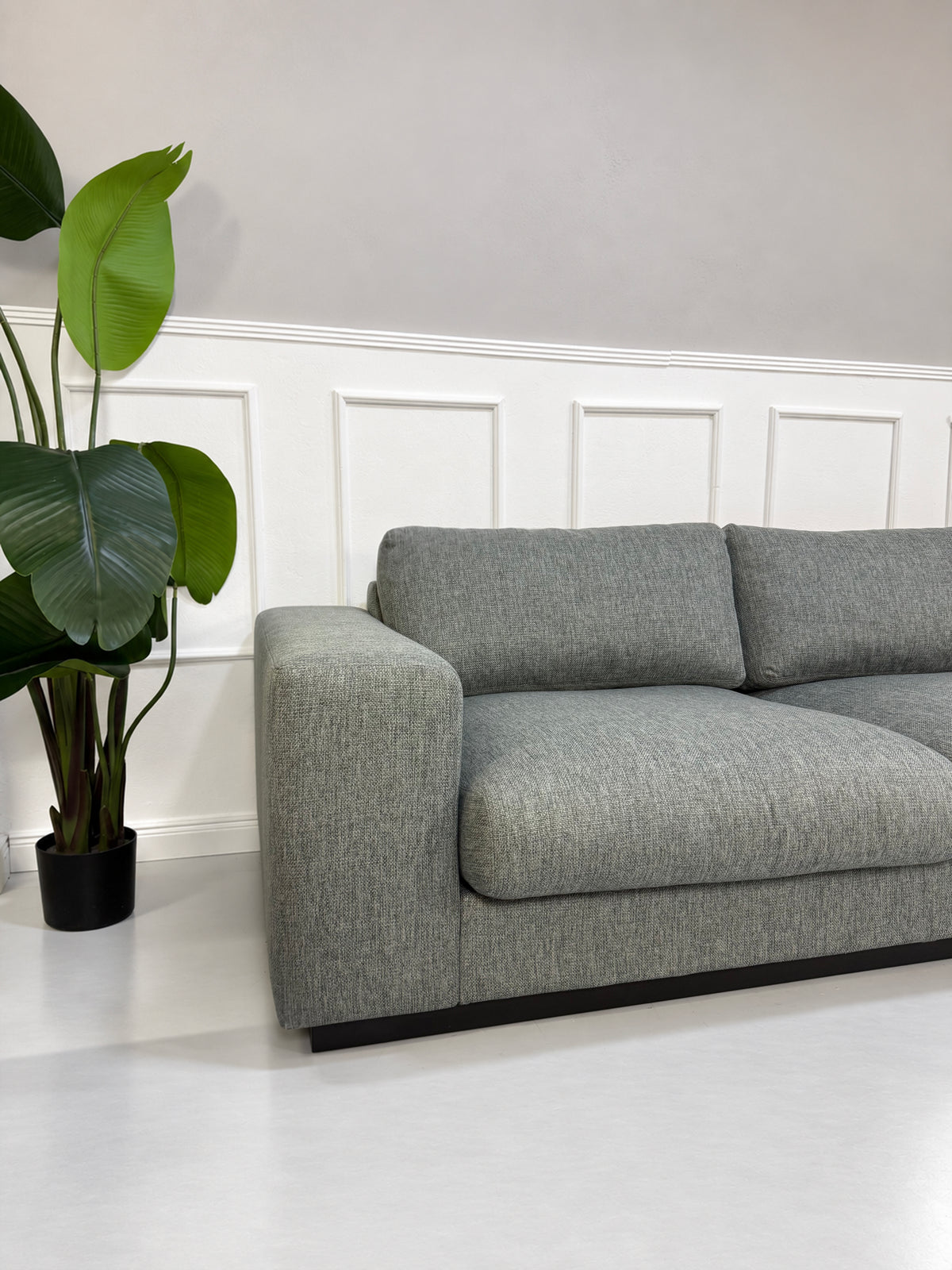 Gebrauchtes graues Bolia Sepia Designer Stoff Ecksofa vor einer Wand, stilvoll und modern eingerichtet.