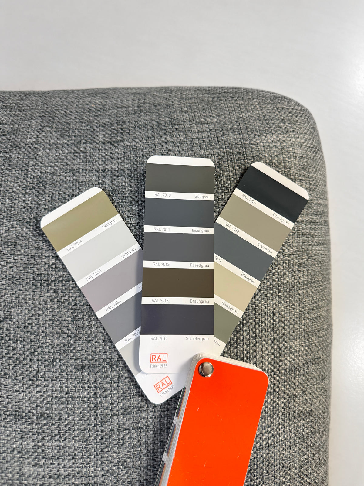 Gebrauchtes graues Bolia Sepia Designer Stoff Ecksofa vor einer Wand, stilvoll und modern eingerichtet.