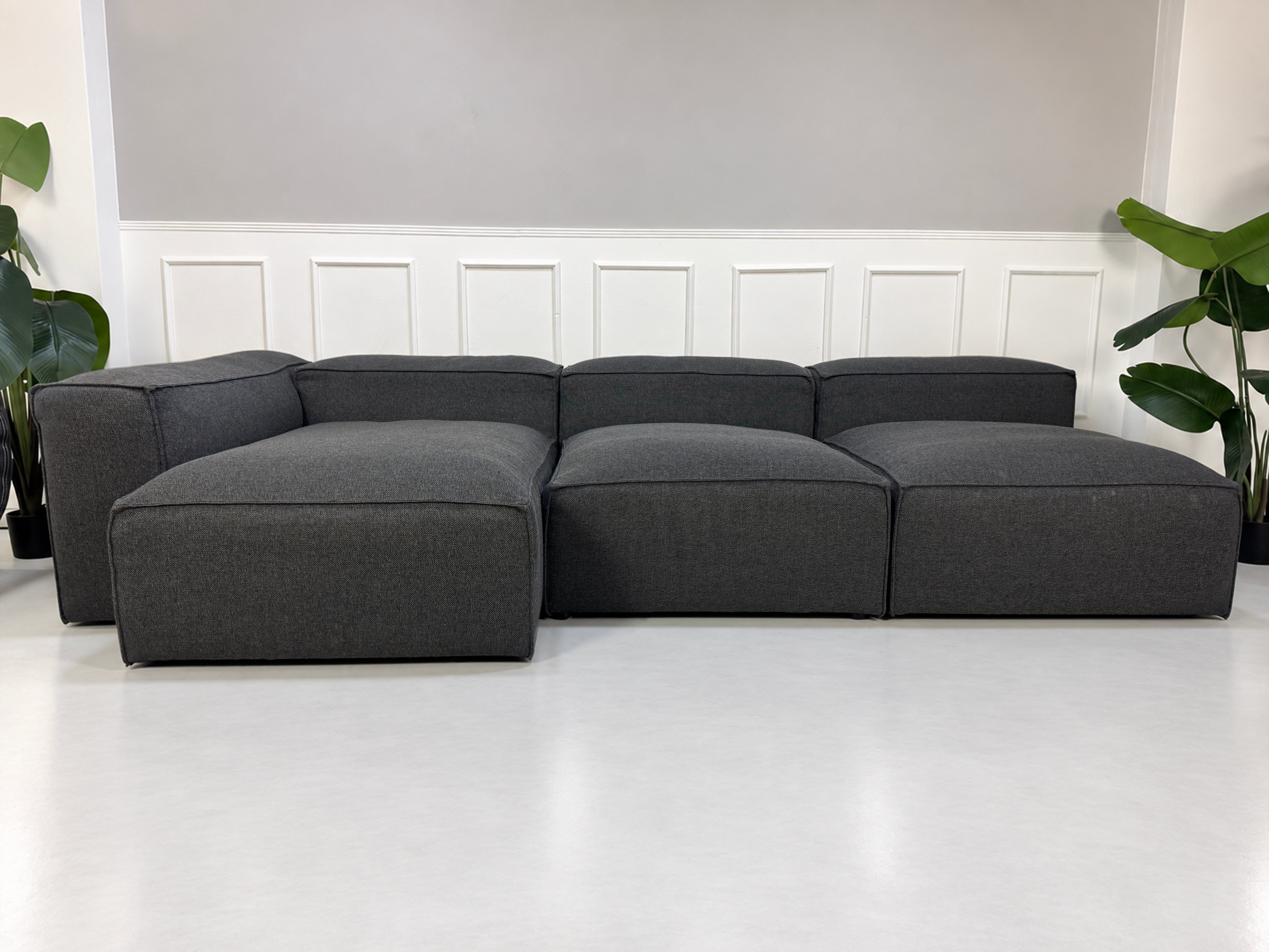 Gebrauchtes graues Bolia Cosima Designer Stoff Sofa vor einer Wand, stilvoll und modern eingerichtet.