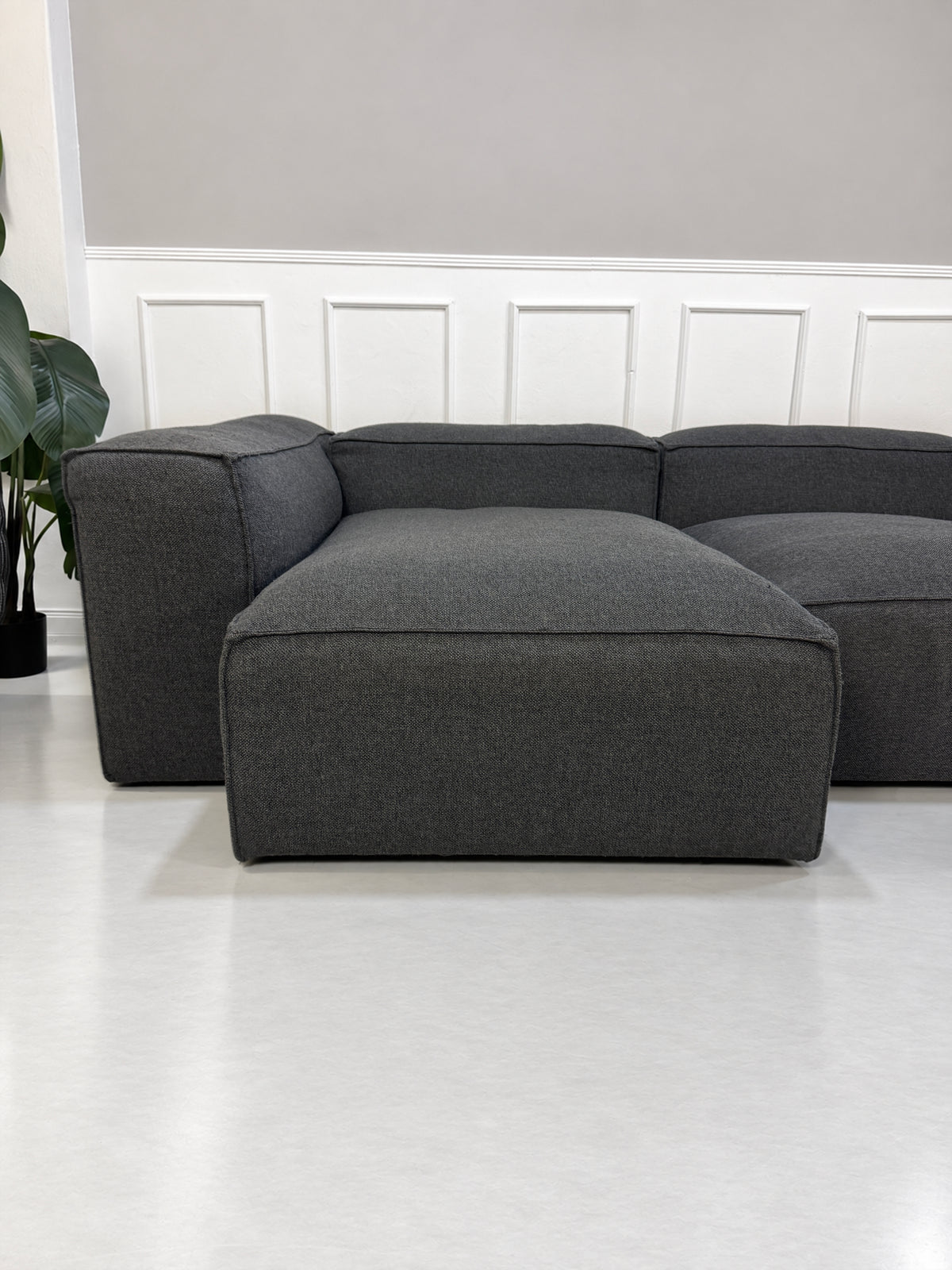Gebrauchtes graues Bolia Cosima Designer Stoff Sofa vor einer Wand, stilvoll und modern eingerichtet.