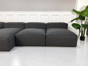 Gebrauchtes graues Bolia Cosima Designer Stoff Sofa vor einer Wand, stilvoll und modern eingerichtet.