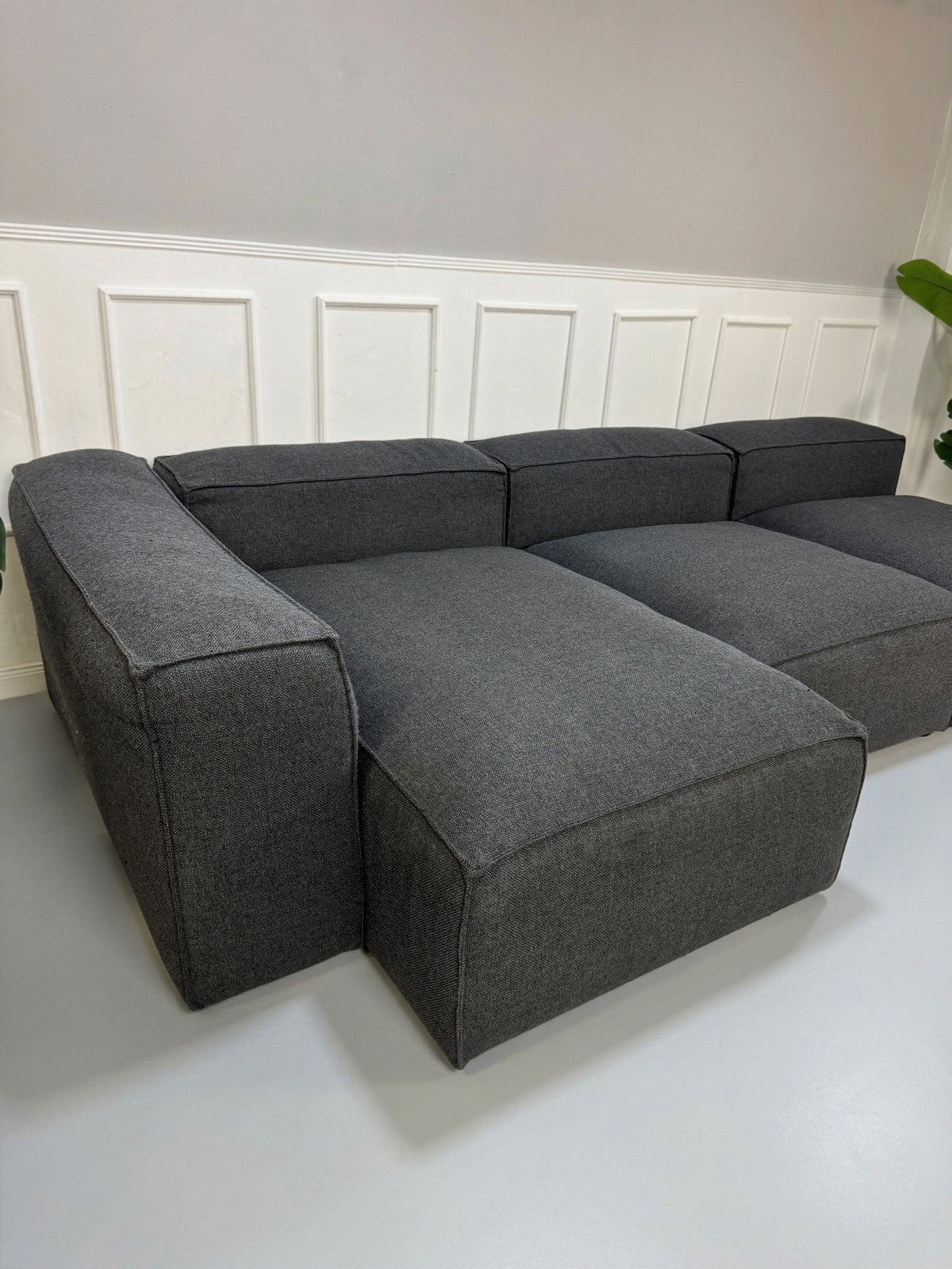 Gebrauchtes graues Bolia Cosima Designer Stoff Sofa vor einer Wand, stilvoll und modern eingerichtet.