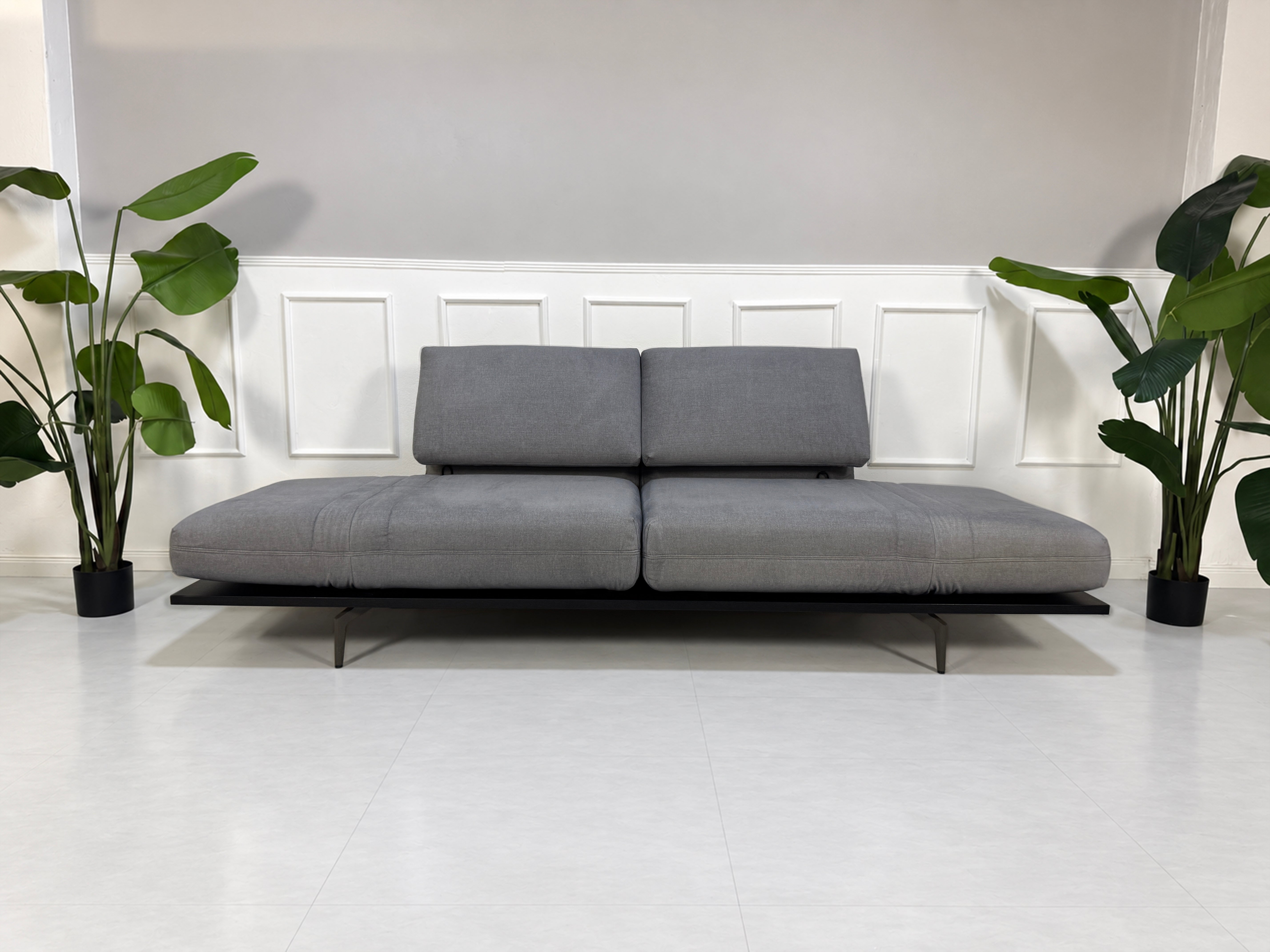 Gebrauchtes grau-blaues Rolf Benz Aura Designer Stoff Sofa vor einer Wand, stilvoll und modern eingerichtet.