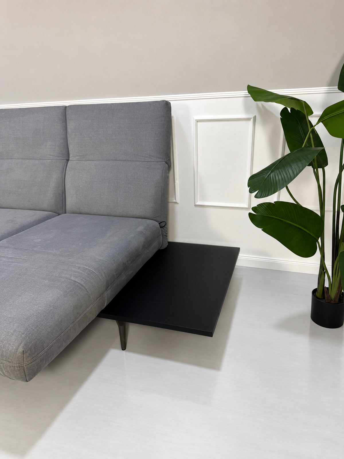 Gebrauchtes grau-blaues Rolf Benz Aura Designer Stoff Sofa vor einer Wand, stilvoll und modern eingerichtet.