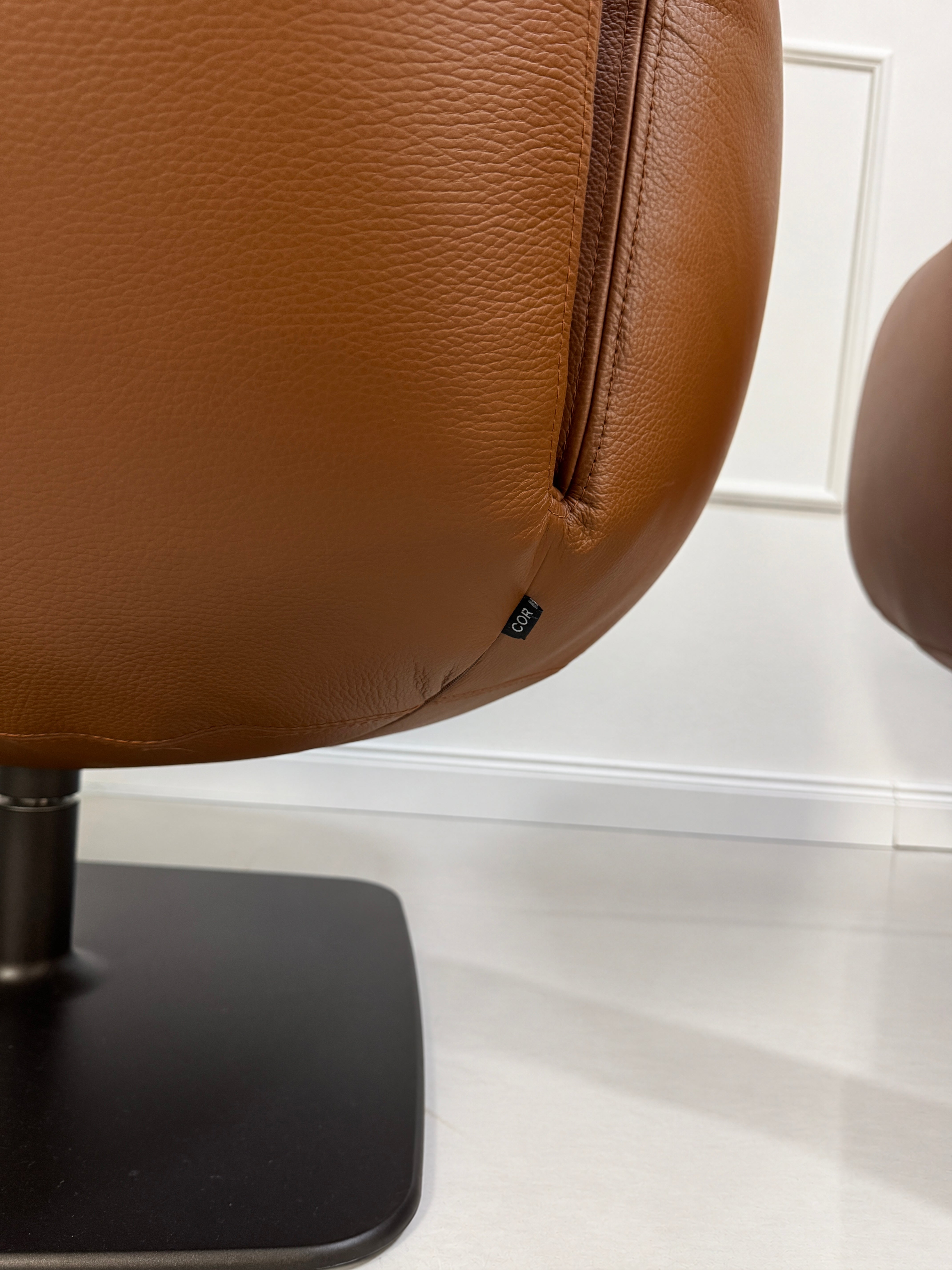 Gebrauchter brauner COR Jalis Designer Leder Sessel vor einer Wand, stilvoll und modern eingerichtet.