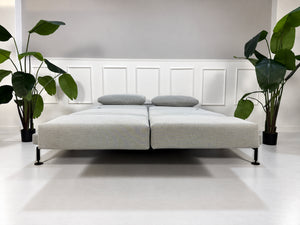 Gebrauchtes graues Brühl Moule Medium Designer Stoff Sofa mit Ablage und Hocker vor einer Wand, stilvoll und modern eingerichtet.