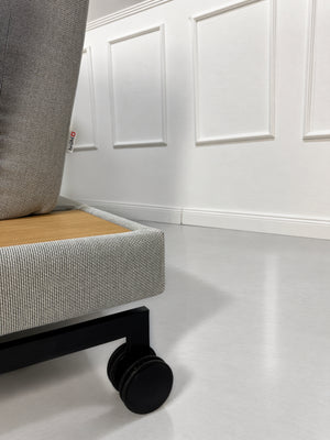 Gebrauchtes graues Brühl Moule Medium Designer Stoff Sofa mit Ablage und Hocker vor einer Wand, stilvoll und modern eingerichtet.