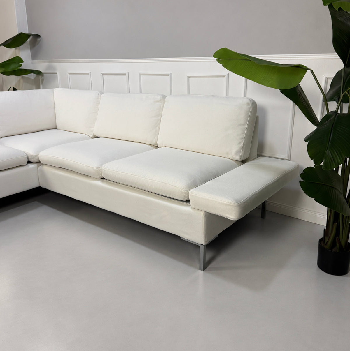 Gebrauchtes weißes Brühl Alba Designer Stoff Ecksofa vor einer Wand, stilvoll und modern eingerichtet.