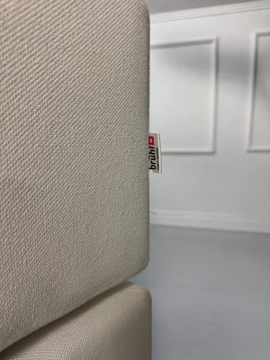 Gebrauchtes weißes Brühl Alba Designer Stoff Ecksofa vor einer Wand, stilvoll und modern eingerichtet.